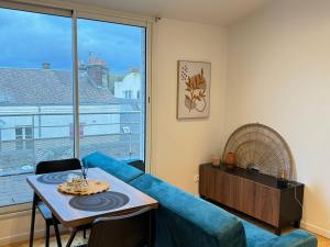 un salon avec un canapé bleu et une table dans l'établissement La Terrasse du Havre, au Havre