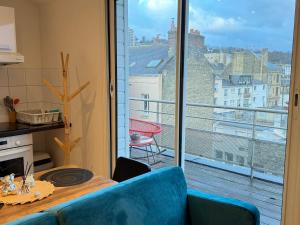 une cuisine avec une table et une vue sur un balcon dans l'établissement La Terrasse du Havre, au Havre 7 autres photos