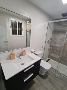a bathroom with a sink and a toilet and a mirror at Apartamento con vistas al Mar en Cambrils in Cambrils +58 photos