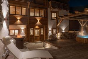 Una sala de estar con una silla blanca y suelo de madera en Chalet La Louvetiere 14 persones 6 chambres, en Le Bez