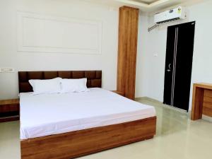 KāhārpāraHotel O Happy Homes Resort的卧室里有一张铺着白色床单的床和一扇窗户