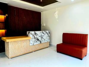 KāhārpāraHotel O Happy Homes Resort的房间里有一把红色椅子和一个柜台