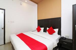 a bedroom with a large bed with red pillows at Super Hotel O by OYO Surya Continental in Lucknow +63 photos