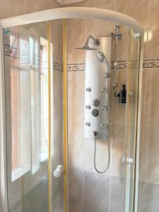 马塞卢AuusiMA Family Stay的浴室里有玻璃门的淋浴间