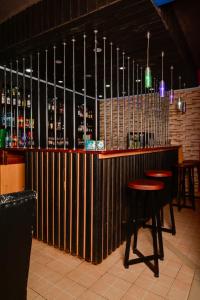 un bar con taburetes de madera y botellas de alcohol en Snow Peak Hotel in Chogoria, en Mwangarimwe