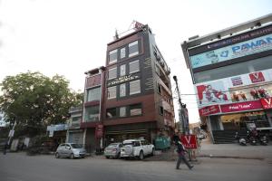 a man walking down a street in front of a building at Super Hotel O by OYO Surya Continental in Lucknow