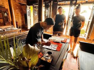 un hombre preparando comida en una mesa en un restaurante en ANN GARDEN RETREAT Cat Ba, en Cat Ba