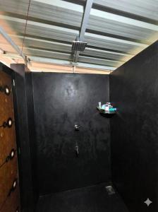 een badkamer met een zwarte muur en een plafond bij The Kadu in Tāzhekkod