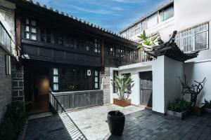 een binnenplaats van een gebouw met planten en gebouwen bij Dongsheng Design Hotel in Dali in Dali
