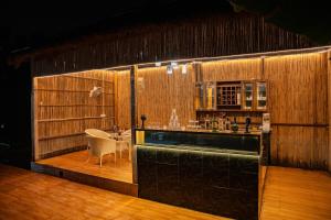 a kitchen with a bar and a table in a room at Aurea 4-BHK Farmhouse With Private Pool, Garden & Gazebo in Greater Noida