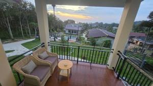 a balcony with two chairs and a table and a view at Samati Hill - Sunset Pool Villa 6 - Klong Ning Beach in Ko Lanta Yai