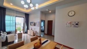 a dining room with a table and a clock on the wall at Samati Hill - Sunset Pool Villa 6 - Klong Ning Beach in Ko Lanta Yai