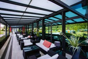 塞塔拉AN Park Hotel Milano Settala的一个带沙发和桌子的温室以及窗户