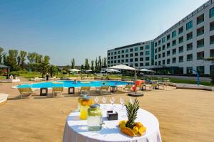 塞塔拉AN Park Hotel Milano Settala的一张桌子,上面有水果,放在游泳池前