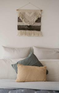 a bedroom with a white bed with pillows and a wall at Neptunes Guest House in Port Campbell