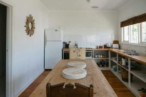 a kitchen with a wooden table and a refrigerator at Neptunes Guest House in Port Campbell