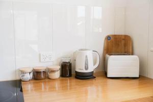 a kitchen counter with a coffee maker and a toaster at Neptunes Guest House in Port Campbell