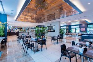 塞塔拉AN Park Hotel Milano Settala的有桌椅和酒吧的餐厅