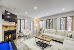 een woonkamer met een witte bank en een open haard bij Pool Table - Elegance - Comfort - Le Chic Boreal in Saint-Jovite
