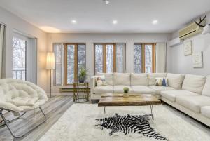 een woonkamer met een witte bank en een tafel bij Pool Table - Elegance - Comfort - Le Chic Boreal in Saint-Jovite