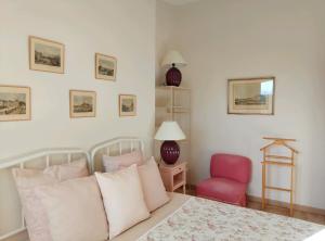 a bedroom with a bed and a red chair at La Procureuse in Barjols +25 photos
