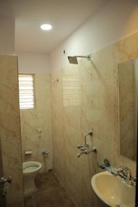 Best Buy Hotel في كولْكاتا: حمام مزود بمرحاض ومغسلة ومرآة