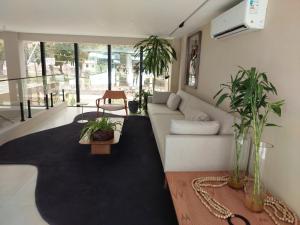 a living room with a couch and some plants at Studio Gardenia Mobiliado - Batista Campos in Belém