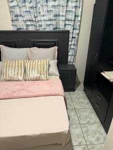 a bedroom with a bed with a black headboard at Namasiku 's Self Catering in Khomas Region