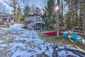 Ein Haus im Wald mit Schnee auf dem Boden in der Unterkunft Lake Front-Spa Tub-Fire Pit-Full Kitchen-Canoe in Bucksport