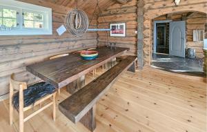 Holzzimmer mit einem Holztisch in einer Hütte in der Unterkunft Cozy Home In Eggedal With Wifi in Surteberg