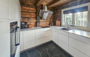 eine Küche mit weißen Schränken und einer Spüle und einem Fenster in der Unterkunft Cozy Home In Eggedal With Wifi in Surteberg