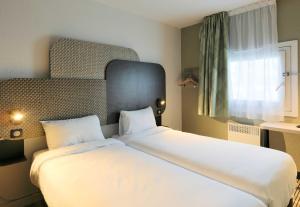 Ένα ή περισσότερα κρεβάτια σε δωμάτιο στο B&B HOTEL Cergy Pierrelaye