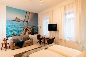 Kapitaenshaus-Lassen-Zimmer-Santa-Maria في فيسترلاند: غرفة فندق بها سرير ولوحة مركب شراعي على الحائط