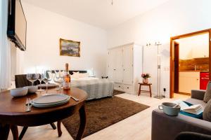 Kapitaenshaus-Lassen-Zimmer-Santa-Maria في فيسترلاند: غرفة معيشة مع سرير وطاولة مع كؤوس للنبيذ