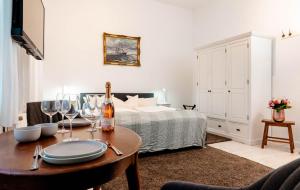 Kapitaenshaus-Lassen-Zimmer-Santa-Maria في فيسترلاند: غرفة نوم مع سرير وطاولة مع كؤوس للنبيذ