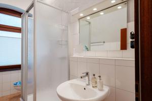 Kapitaenshaus-Lassen-Zimmer-Santa-Maria في فيسترلاند: حمام أبيض مع حوض ومرآة +12 صورة