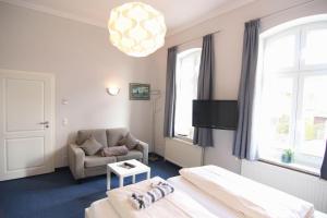 Kapitaenshaus-Lassen-Zimmer-Amistad في فيسترلاند: غرفة فندق مع سرير وكرسي