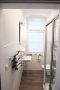 Kapitaenshaus-Lassen-Zimmer-Amistad في فيسترلاند: حمام أبيض مع حوض ومرحاض