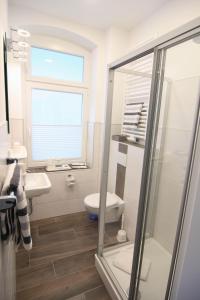 Kapitaenshaus-Lassen-Zimmer-Amistad في فيسترلاند: حمام أبيض مع مرحاض ومغسلة