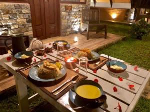 a table with plates of food and a bowl of soup at Rock Garden Villa Pinnawala in Rambukkana