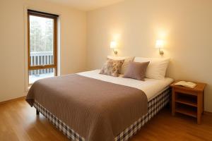 a bedroom with a bed with two lamps and a window at Kongsberg Booking in Kongsberg +52 photos