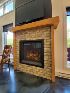 a fireplace with a television on top of it at Relaxation & Comfort - Chalet Sault a la Puce in Sainte-Anne-de-Beaupré