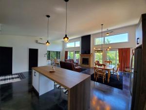 a kitchen and living room with a table and chairs at Relaxation & Comfort - Chalet Sault a la Puce in Sainte-Anne-de-Beaupré