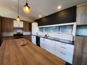 a large kitchen with white cabinets and a wooden floor at Relaxation & Comfort - Chalet Sault a la Puce in Sainte-Anne-de-Beaupré +16 photos