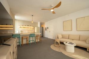 a living room with a couch and a kitchen at Ático A-mar in Puerto Naos