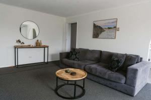 a living room with a couch and a table at Beacon Point House in Port Campbell