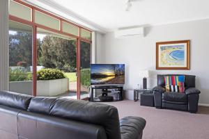 モリーモックにあるFathoms 2 - 2BR beach resort apartmentのリビングルーム(革張りのソファ、薄型テレビ付)