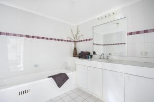 モリーモックにあるFathoms 2 - 2BR beach resort apartmentの浴槽と洗面台のある白いバスルーム