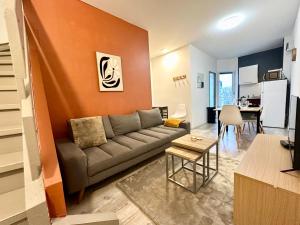 een woonkamer met een bank en een tafel bij Le Cocon Urbain - Spacieux - Hyper Centre in Mont-de-Marsan +10 foto's