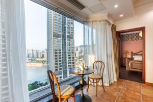 a room with a table and chairs and a large window at Guyu B&B in Chongqing